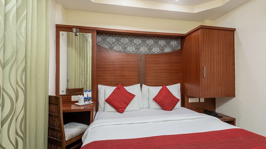 Bedroom with a king size bed and a bottled water and a glass placed next to it  at DLS Hotels The Rock Castle.